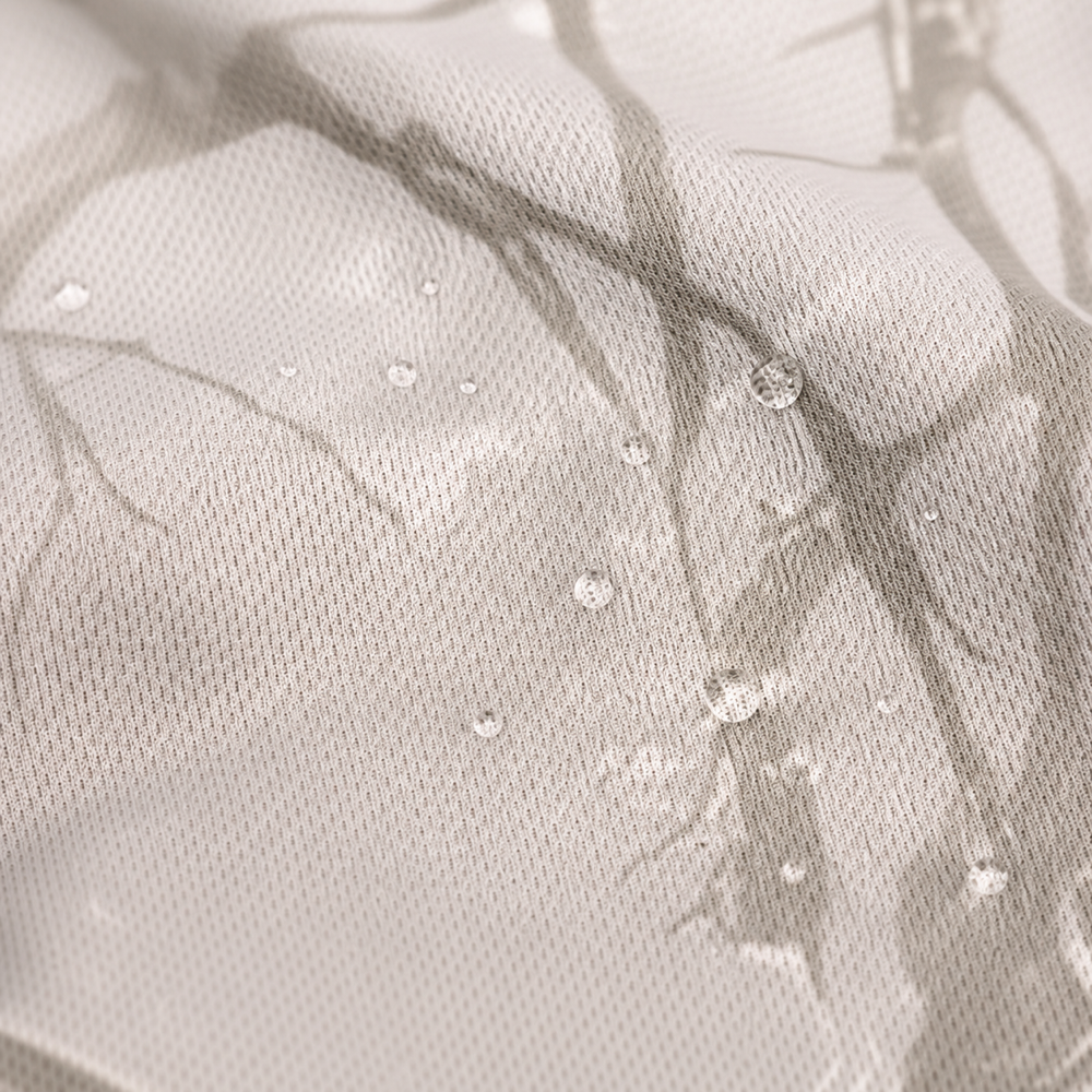Close-up of tan camo mesh fabric with water droplets beading on the surface