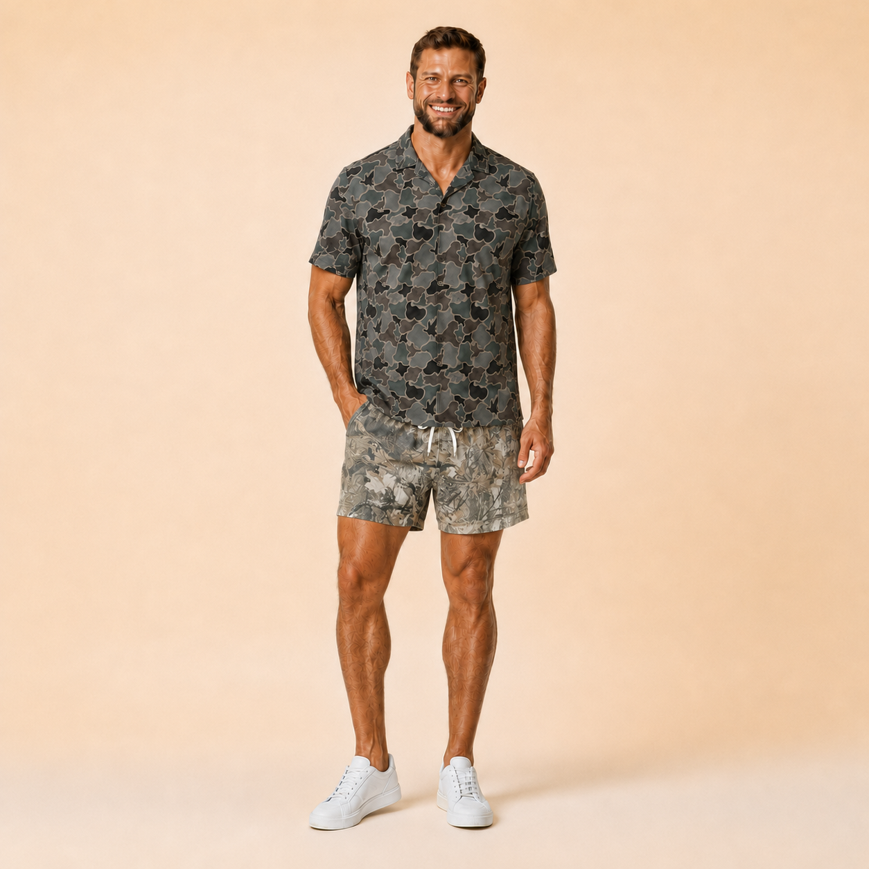 Man wearing Silpaz realistic camo mesh shorts in Tan Leaf Camo with a dark camp shirt, full length front view