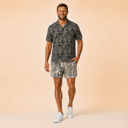 Man wearing Silpaz realistic camo mesh shorts with a dark camp shirt, standing front view