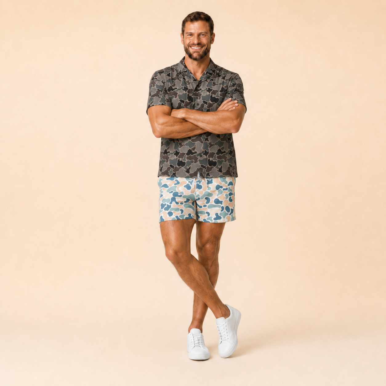 Man wearing Silpaz duck camo athletic shorts in cream blue camo, arms crossed, full length view