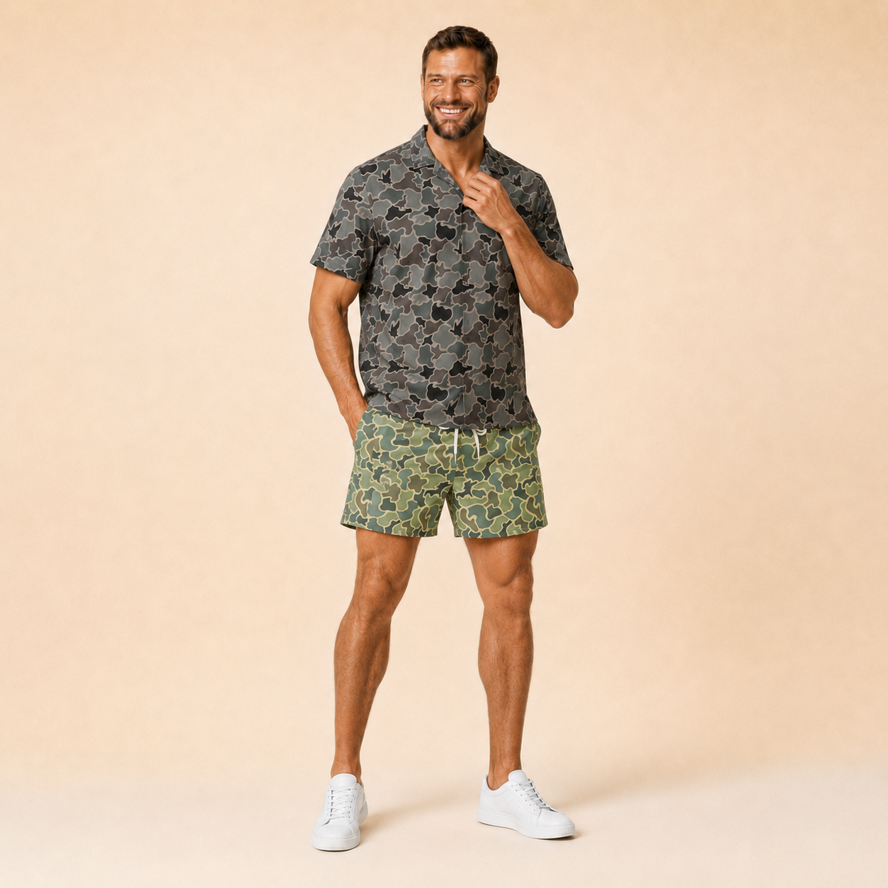 Man wearing Silpaz duck camo athletic shorts in Sage Green Camo with a dark camp shirt, full length front view