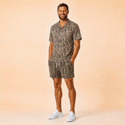 Man wearing Silpaz tree bark camo mesh shorts with a matching camp shirt, full length front view